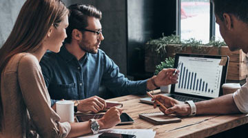group of people looking at analytics on laptop
