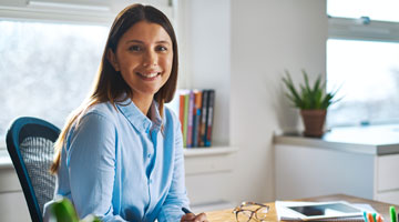 Woman sitting at her desk smiling