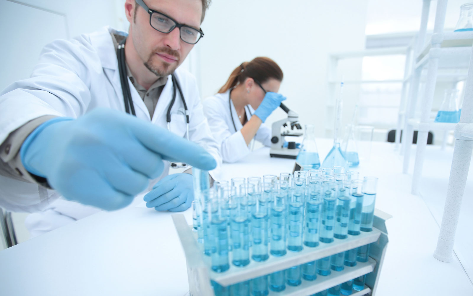 Man in laboratory talking samples from test tubes