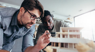 Men in office discussing architectural model