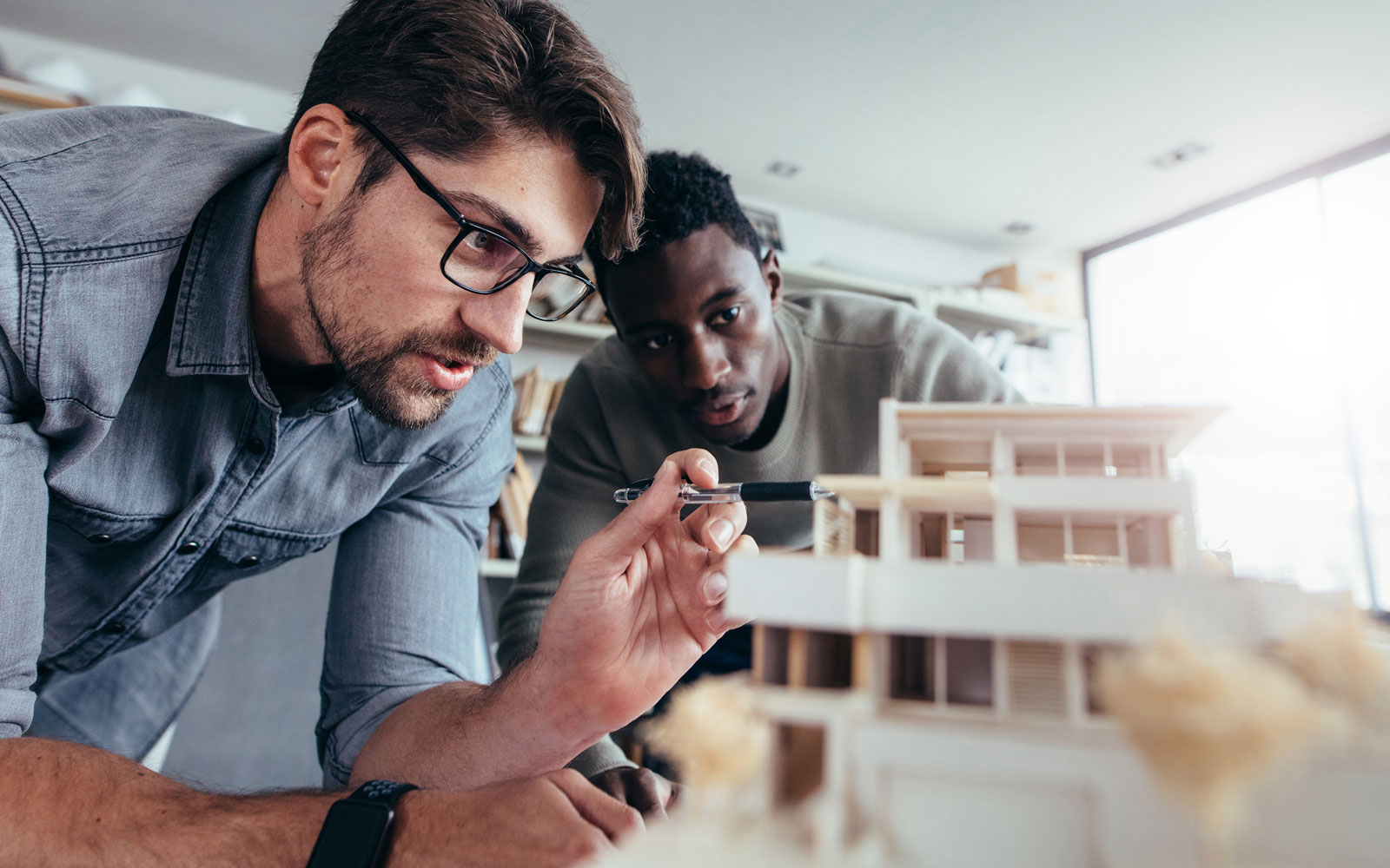 Men in office discussing architectural model