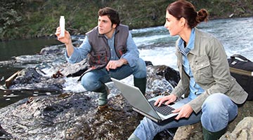 Scientist taking a water sample at a creek