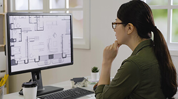 Construction engineer working plans on computer