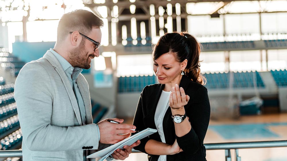 Sports manager discussing with his colleague in a gymnasium