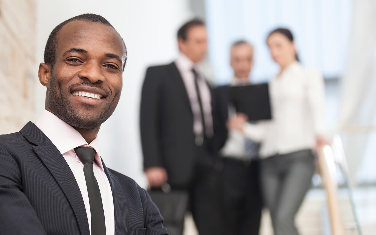 Business manager smiling in front of colleges