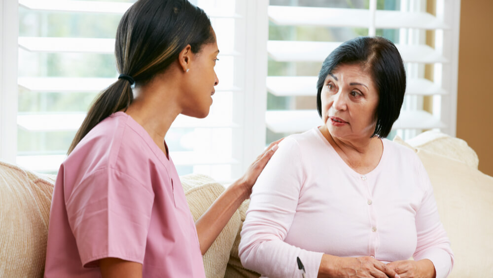 Health worker discussing healthcare with a female patient.