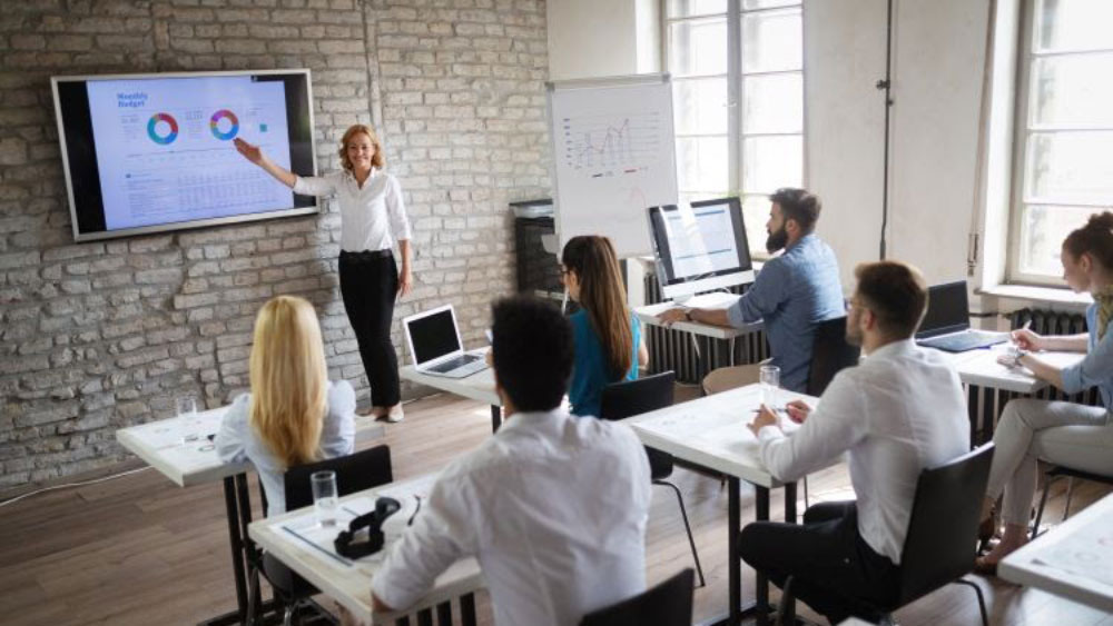 A teacher uses a screen to educate her classroom.