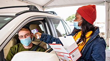 Public health technician taking someone's temperature