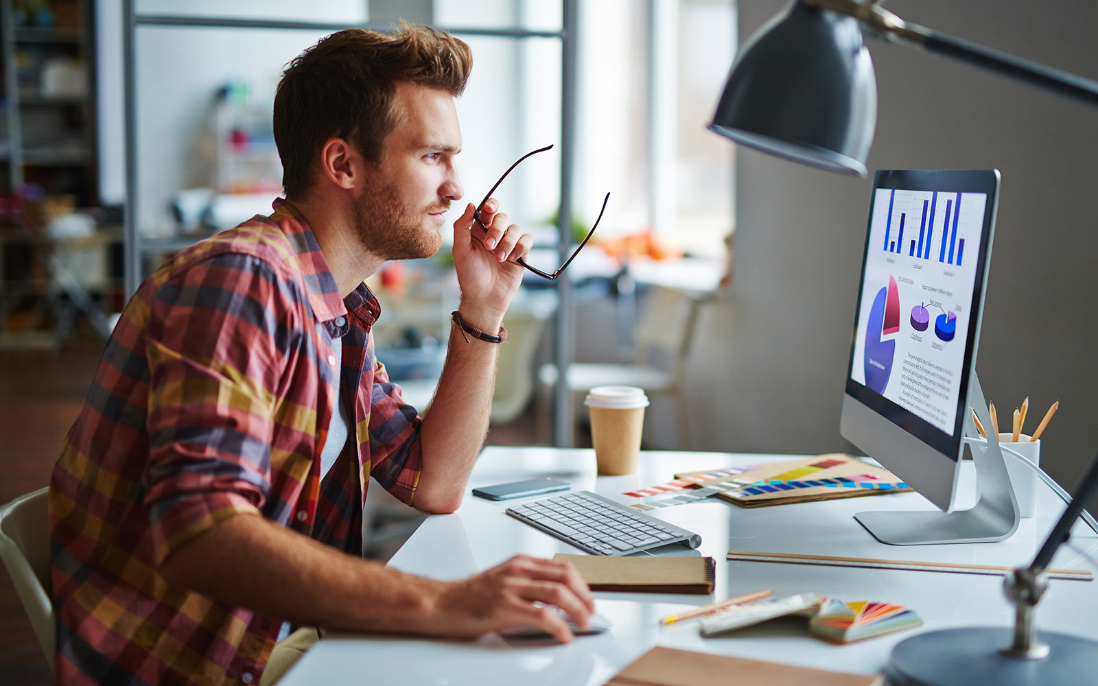 Man at desk analyzing data on computer