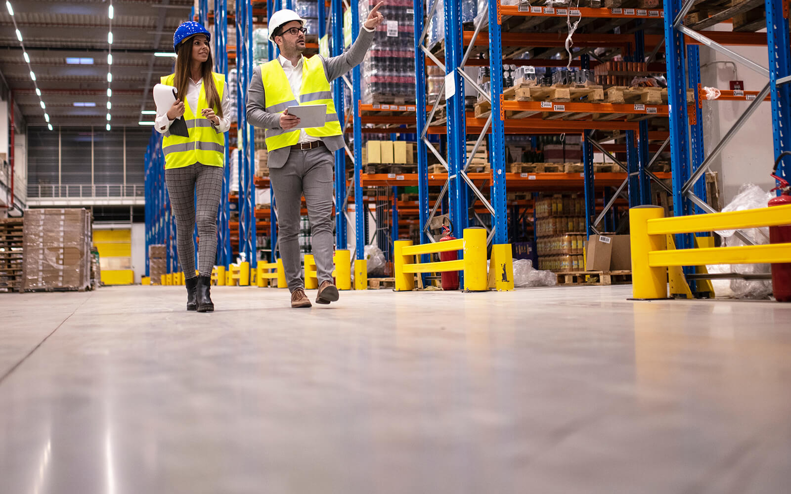 Safety manager walking with employee in warehouse