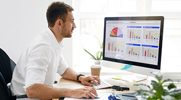 Man at desk analyzing data on computer