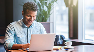 Man working on his laptop computer smiling