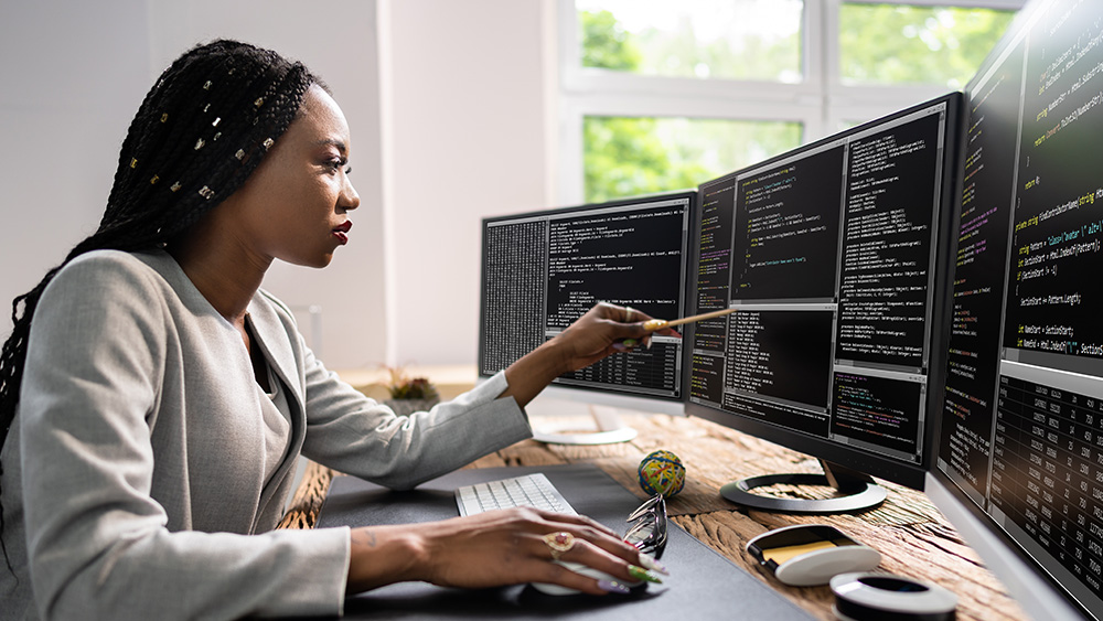 Woman working at desk with computers