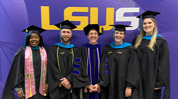 students and professor at photo booth at LSUS commencement