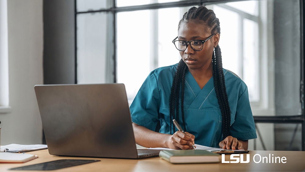 Woman sitting in front of a laptop and writing