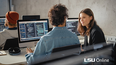 two people talking in front of computer screens